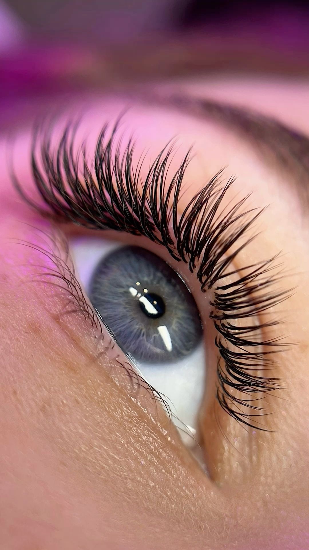 Close-up of a blue eye with curled lash extensions