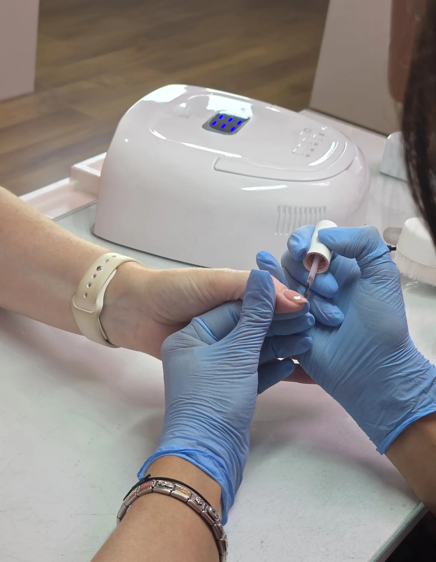 Nail technician shaping a client’s nails at the manicure table